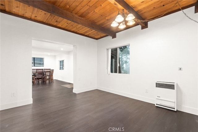 spare room with dark wood-style flooring, a chandelier, heating unit, and beam ceiling