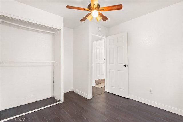 unfurnished bedroom with a ceiling fan, baseboards, dark wood-style flooring, and a closet