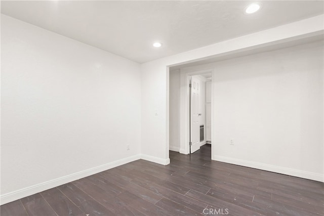 empty room featuring baseboards, recessed lighting, and dark wood-style flooring