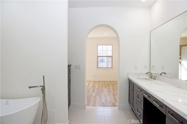 bathroom featuring a bath, tile patterned flooring, and vanity