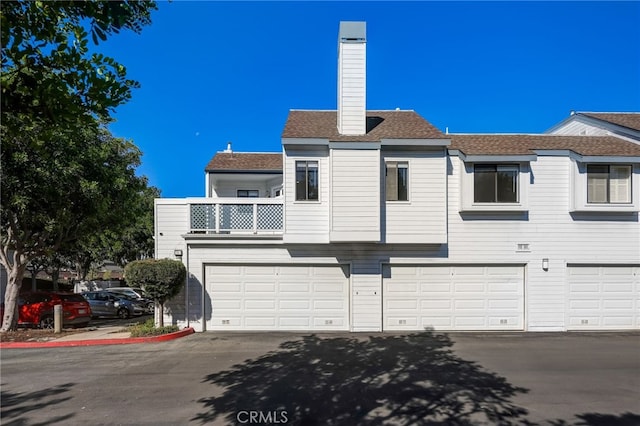 view of front of property with a garage and a balcony