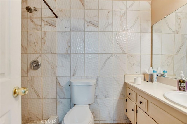 bathroom featuring toilet, tile walls, tiled shower, and vanity