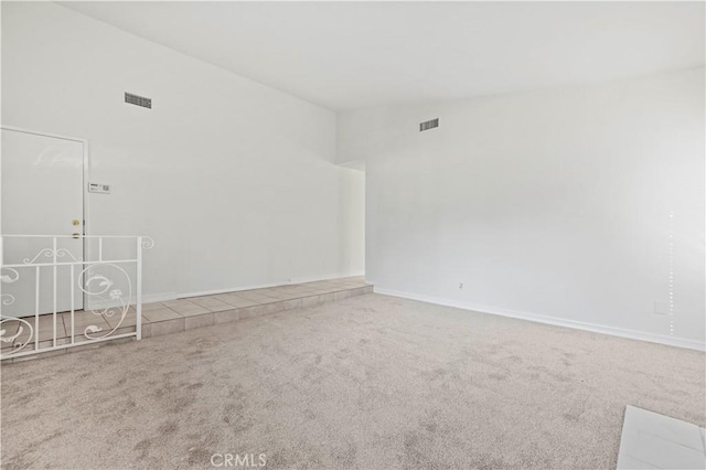 spare room with carpet and high vaulted ceiling