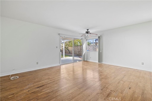 empty room with ceiling fan and light hardwood / wood-style floors