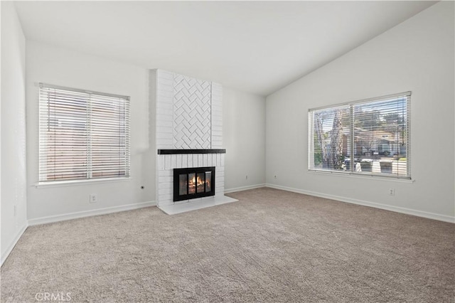 unfurnished living room featuring light carpet, vaulted ceiling, and a fireplace