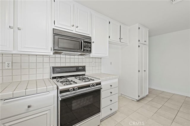 kitchen featuring white cabinetry, tasteful backsplash, white gas range, tile countertops, and light tile patterned floors