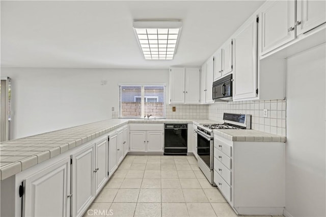 kitchen featuring light tile patterned floors, white cabinetry, tile counters, backsplash, and black appliances