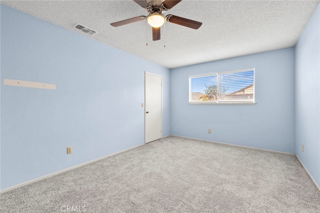 carpeted empty room with a textured ceiling and ceiling fan