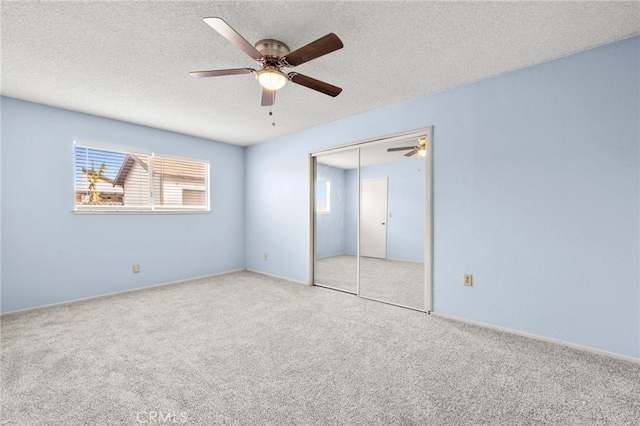 unfurnished bedroom with ceiling fan, a closet, light carpet, and a textured ceiling