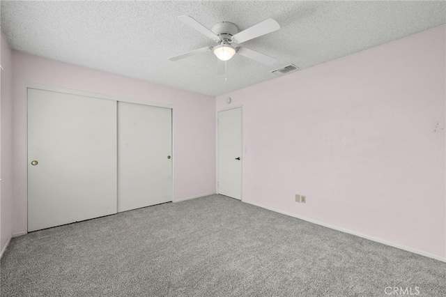 unfurnished bedroom featuring ceiling fan, carpet, a closet, and a textured ceiling