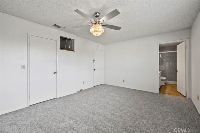 unfurnished bedroom with ceiling fan, carpet, connected bathroom, and a textured ceiling