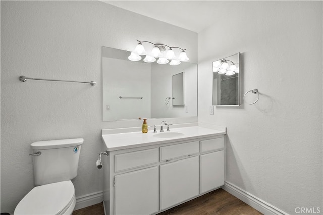 bathroom featuring wood-type flooring, toilet, and vanity