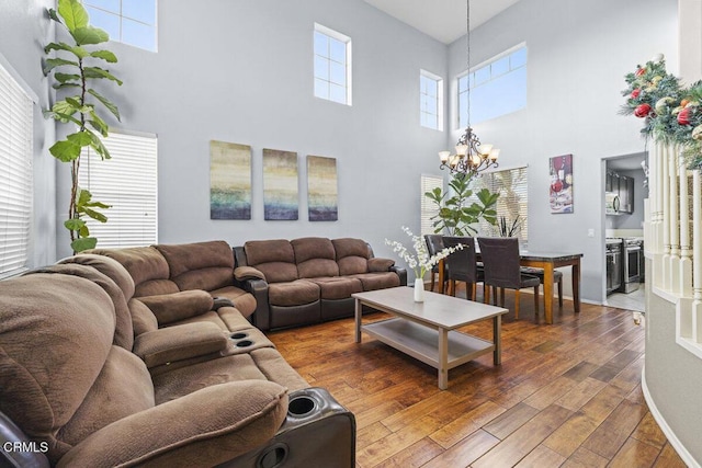 living room with a high ceiling, a chandelier, and dark hardwood / wood-style flooring