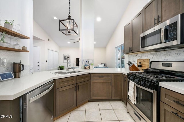 kitchen with kitchen peninsula, appliances with stainless steel finishes, vaulted ceiling, and pendant lighting