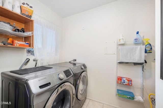 laundry area with light tile patterned floors and washing machine and dryer