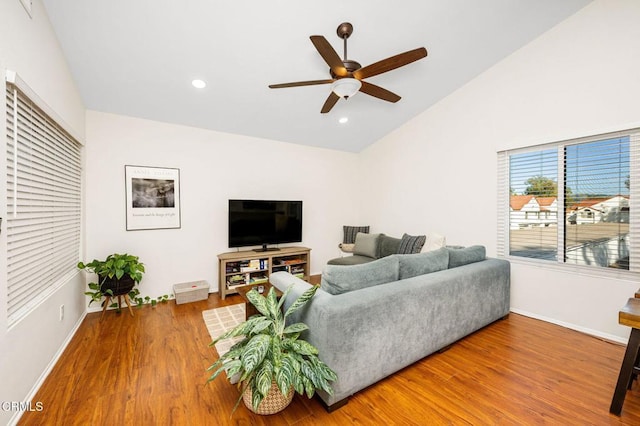 living room featuring ceiling fan, wood-type flooring, and vaulted ceiling