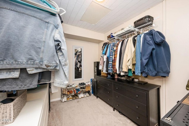 walk in closet with light colored carpet