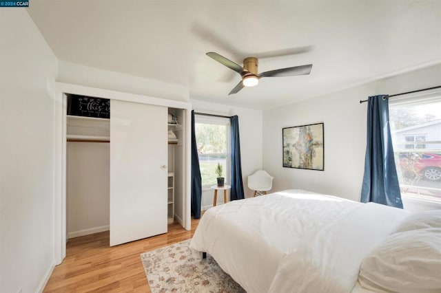 bedroom featuring light wood-type flooring, ceiling fan, and a closet