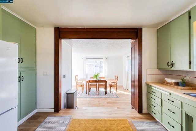 kitchen with green cabinets and white fridge