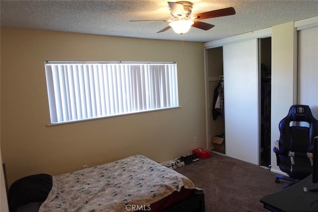 carpeted bedroom with multiple closets, a textured ceiling, and ceiling fan