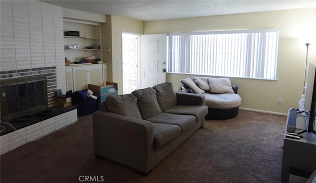 carpeted living room with a textured ceiling and a fireplace