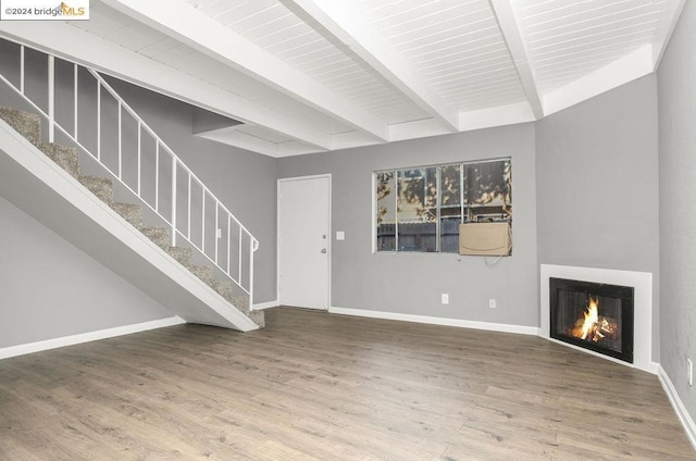 unfurnished living room featuring beam ceiling and hardwood / wood-style floors