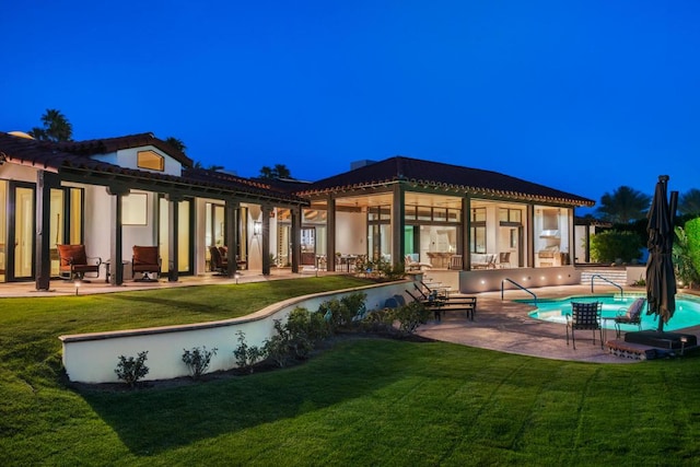 back of house with a yard and a patio