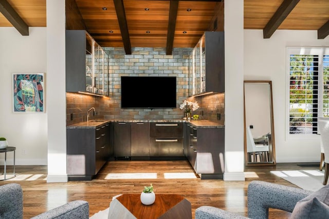 bar with stone counters, decorative backsplash, light wood-type flooring, wood ceiling, and dark brown cabinets