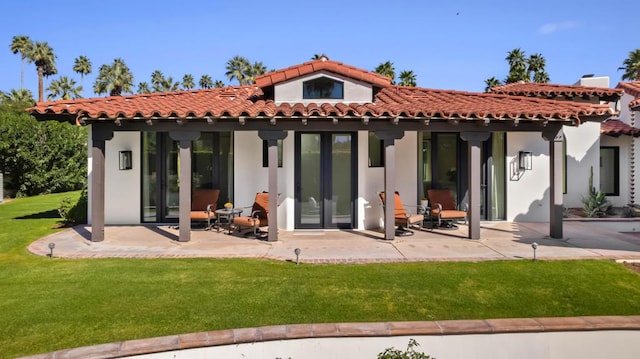 back of house featuring a patio area and a lawn