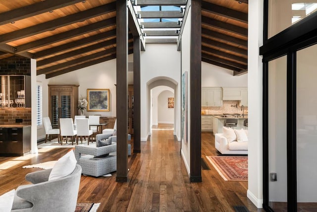 hallway featuring beamed ceiling, dark hardwood / wood-style flooring, wood ceiling, and high vaulted ceiling