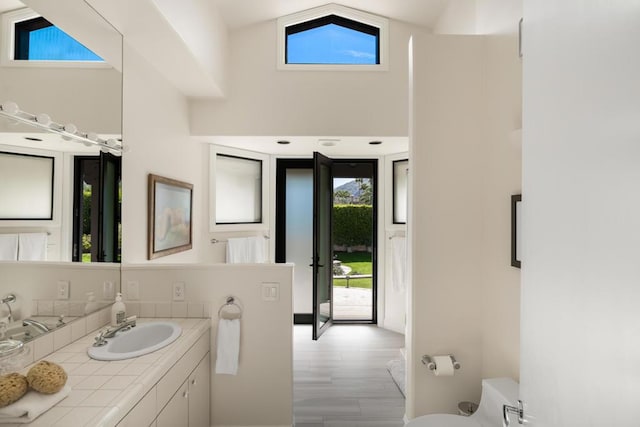 bathroom featuring lofted ceiling, vanity, toilet, and hardwood / wood-style flooring