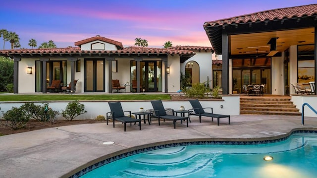 back house at dusk with a patio area