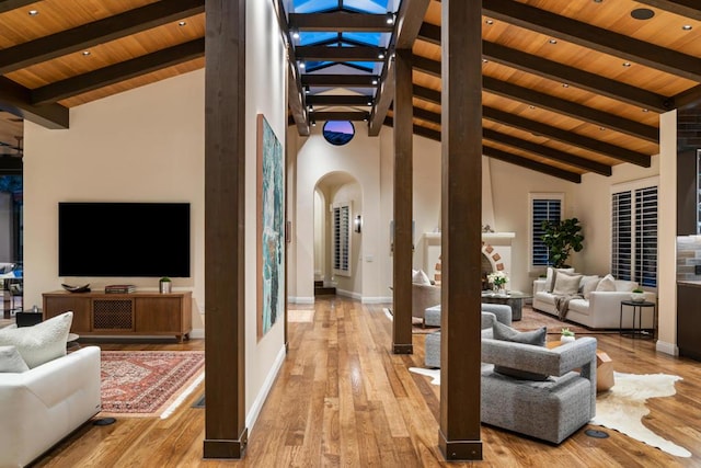 living room featuring high vaulted ceiling, beam ceiling, wood ceiling, and light wood-type flooring