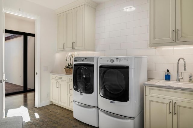 clothes washing area with cabinets, separate washer and dryer, and sink