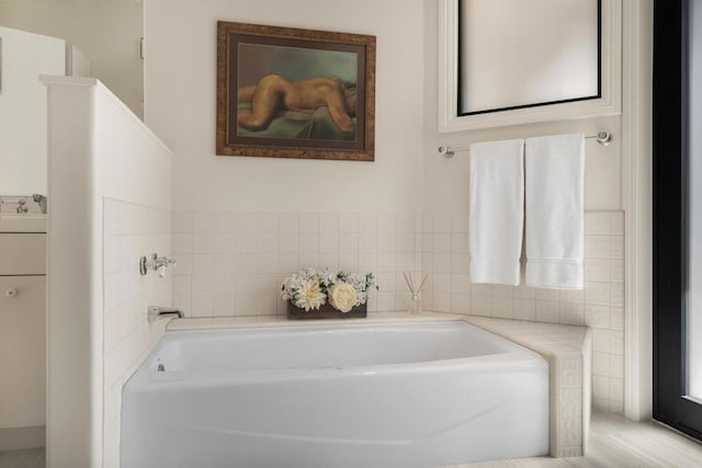 bathroom featuring a tub to relax in and sink