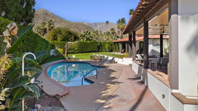 view of swimming pool featuring a mountain view, a yard, and a patio