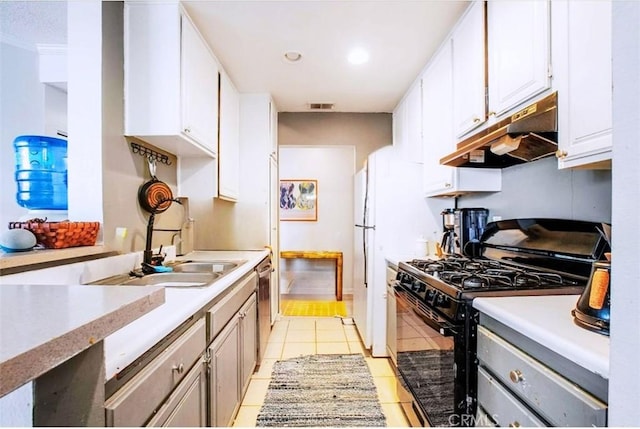 kitchen featuring dishwasher, black range with gas stovetop, light tile patterned floors, sink, and white cabinetry