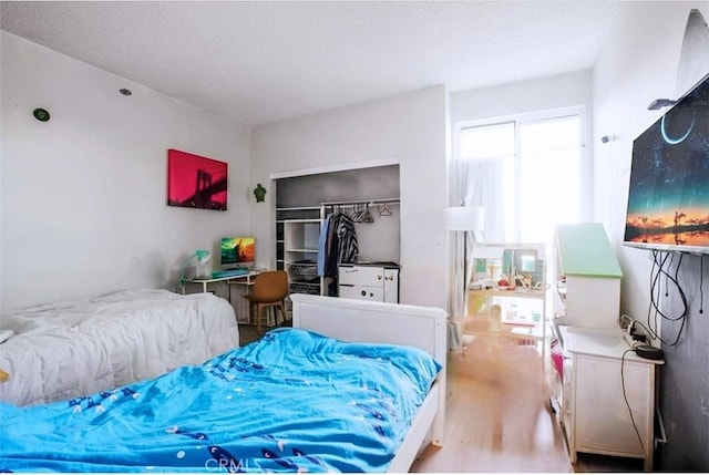 bedroom with hardwood / wood-style floors and a closet