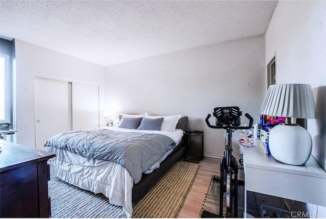 bedroom featuring a textured ceiling and hardwood / wood-style flooring