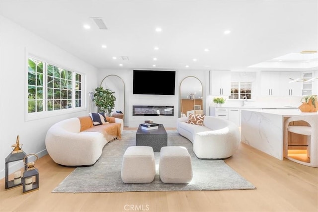 living room featuring sink and light wood-type flooring