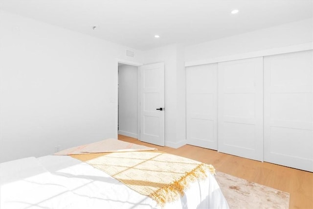 bedroom with a closet and light hardwood / wood-style flooring