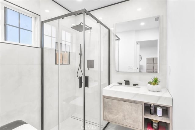 bathroom featuring walk in shower and vanity