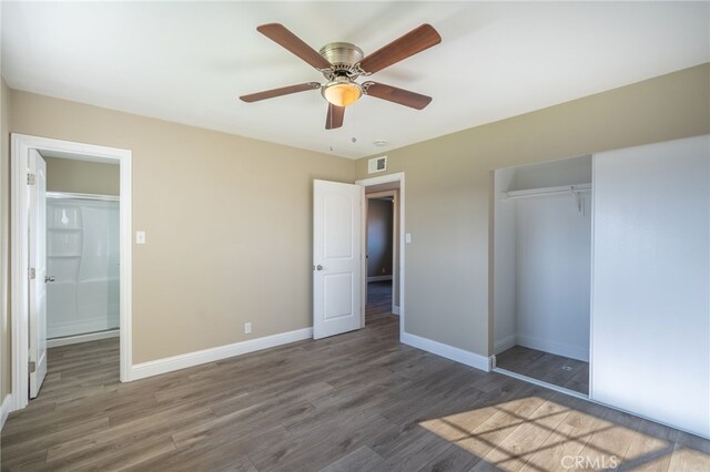 unfurnished bedroom with ceiling fan, a closet, and dark hardwood / wood-style flooring