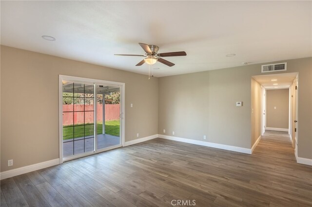 empty room featuring ceiling fan and dark wood-type flooring