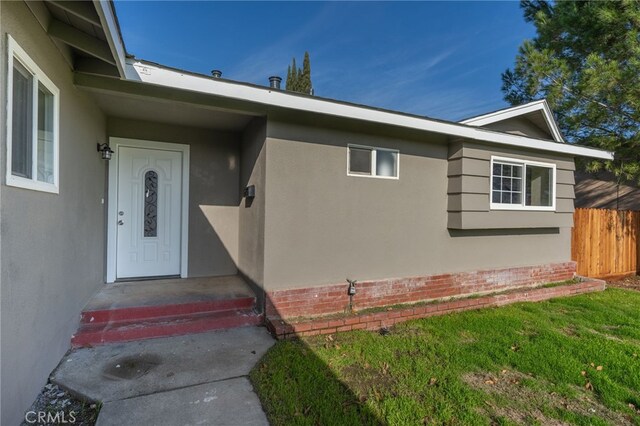 doorway to property with a lawn