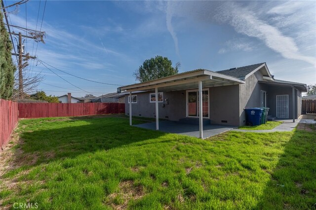 back of property featuring a yard and a patio