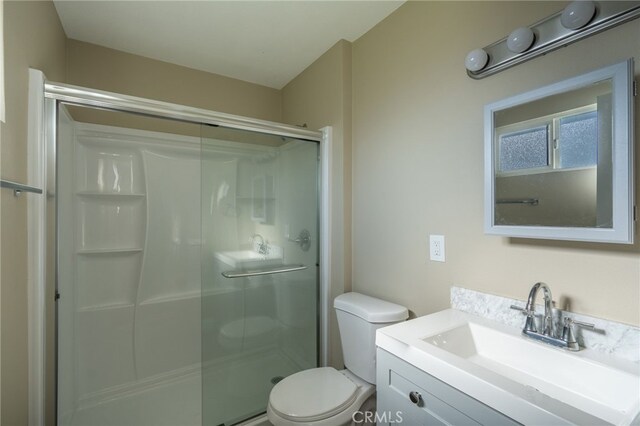 bathroom with toilet, walk in shower, and vanity