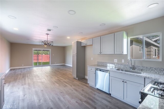 kitchen with stainless steel dishwasher, light stone counters, hanging light fixtures, and sink