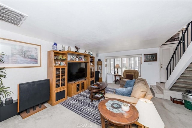 living area featuring carpet floors, stairway, and visible vents