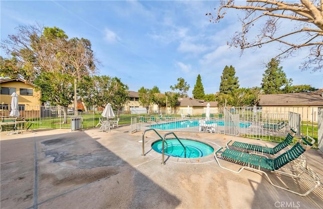 view of swimming pool featuring a hot tub and a patio